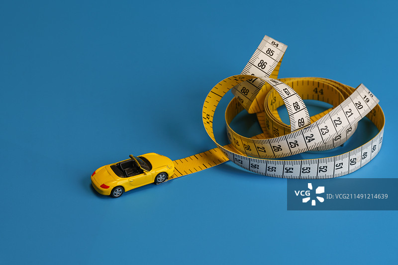黄色汽车在皮尺上行驶里程数微缩创意图图片素材