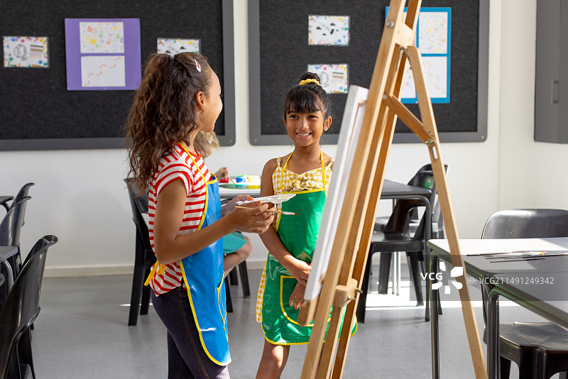 学校美术课上，混血女孩和白人女孩一起绘画图片素材