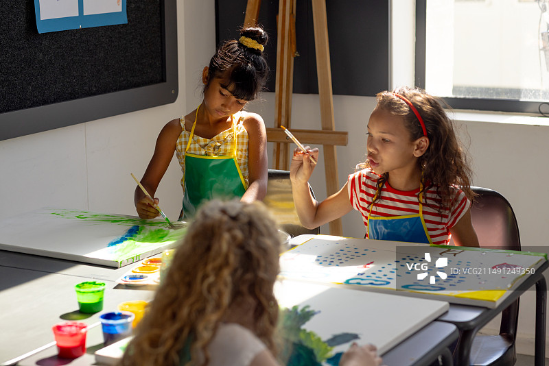 学校美术课：在画布上绘画的年轻学生图片素材