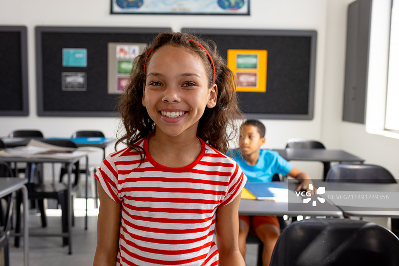 在学校的教室里，一个混血女孩和一个男孩专注于学习图片素材
