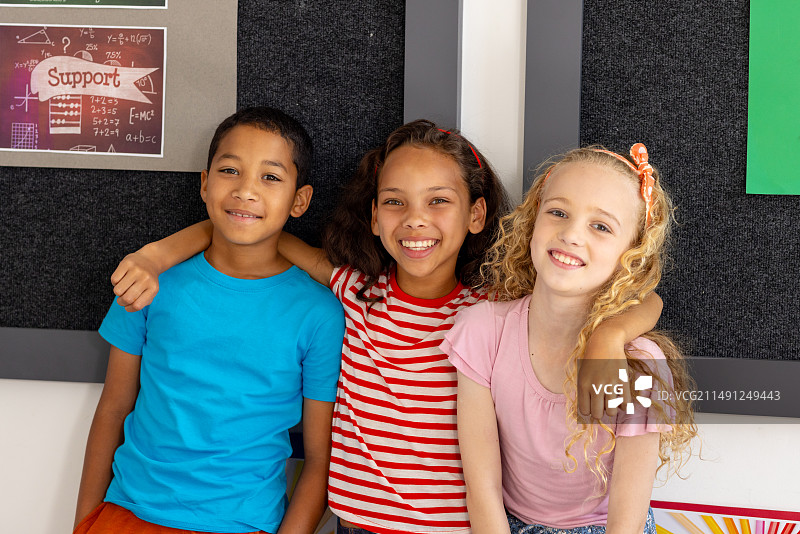 学校里，一群年轻的朋友坐在教室里微笑图片素材