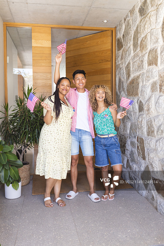朋友们挥舞着美国国旗，站在家门口图片素材