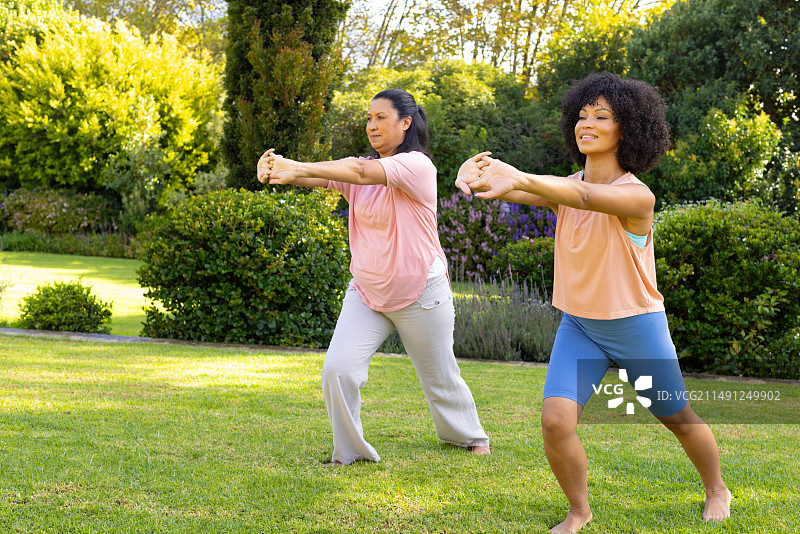 在家中花园锻炼，然后打太极的中年混血女人和年轻混血女人图片素材