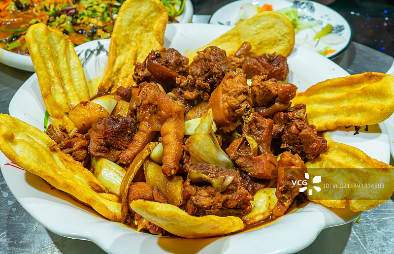 中国餐饮行业饮食产业，传统经典食品，美食拍摄主题，铁锅鸡炖和锅贴美食特写，室内无人图像图片素材