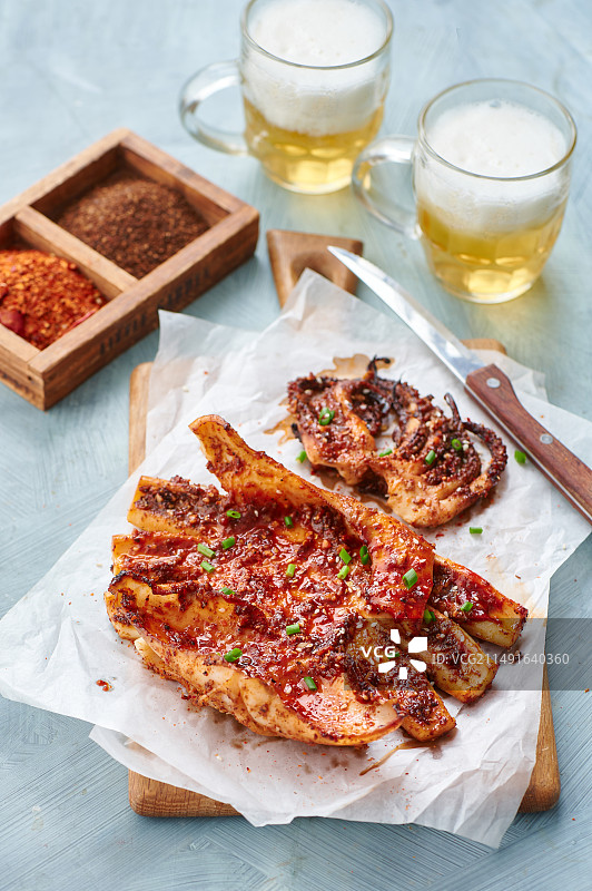 木板上放着的烤鱿鱼和啤酒图片素材