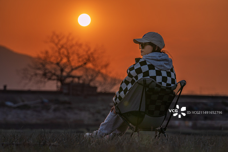 亚洲女子在夕阳下的露营地图片素材