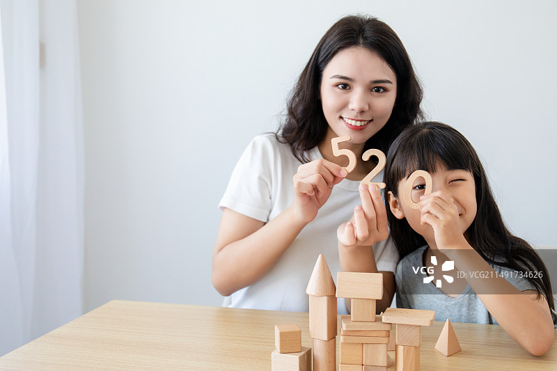 一位中国妈妈陪伴女儿玩积木图片素材
