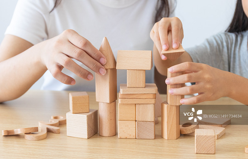 一位中国妈妈陪伴女儿玩积木图片素材