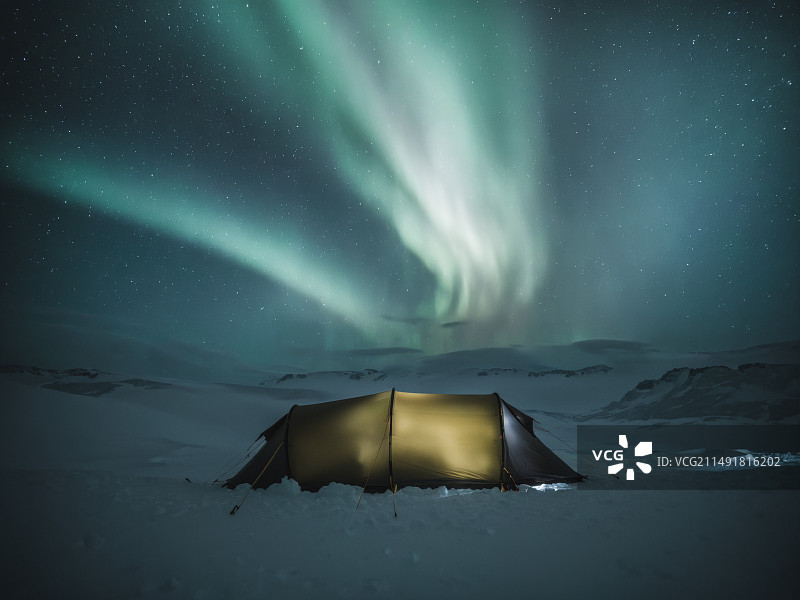 北极光下雪地里旅人的帐篷图片素材