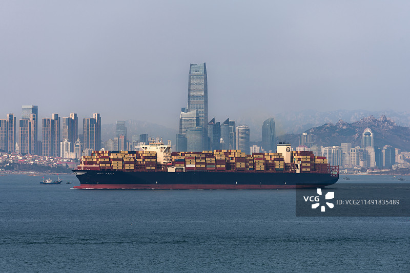 巨型s货轮驶过青岛海天中心图片素材