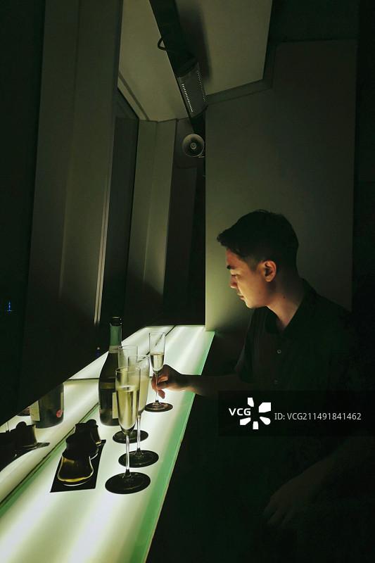 下班后在香港丽思卡尔顿酒店顶楼露台酒吧小酌的男子图片素材