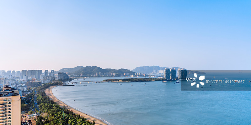 中国海南三亚凤凰岛三亚湾海岸线和城市天际线清晨风光图片素材
