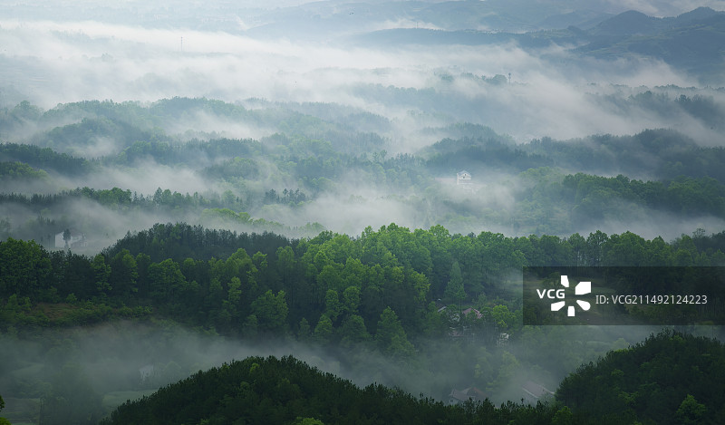 高视角下晨雾环抱的陕西汉中南郑的山谷和村庄图片素材