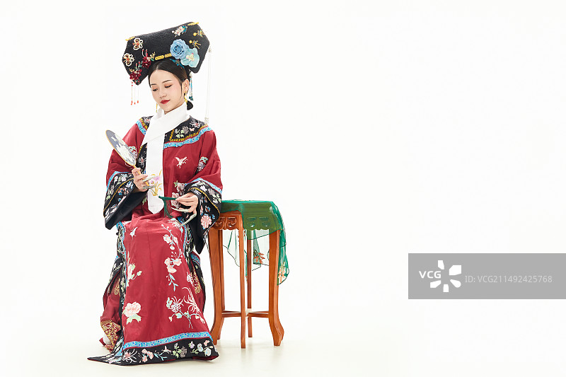 白色背景下穿着中国清朝宫廷服饰的少女图片素材
