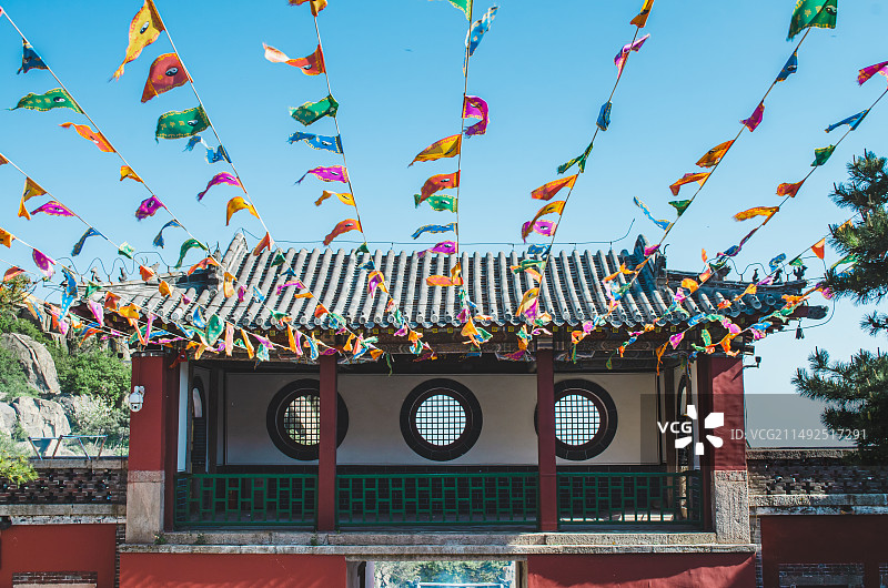 中国非都市风光拍摄主题，山东泰安国内著名景点泰山风景区，玉皇顶碧霞祠寺庙宫殿大门,空中悬挂的道教彩旗图片素材
