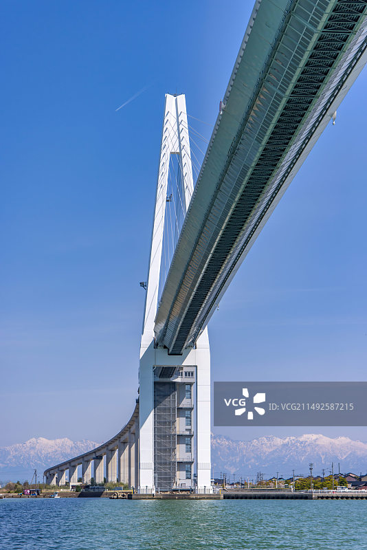 日本富山射水市雪山背景的新凑大桥图片素材