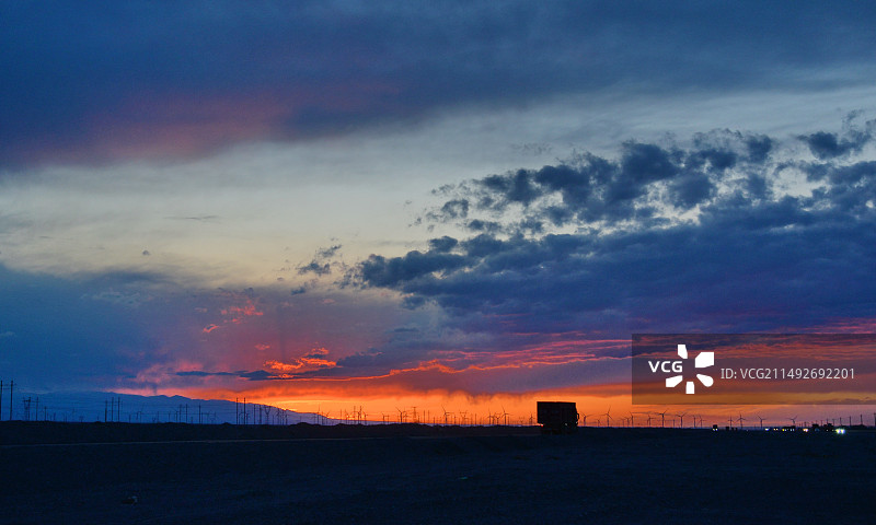 夕阳下，公路边的风力发电机，新疆哈密，伊吾淖毛湖，戈壁滩的风光图片素材