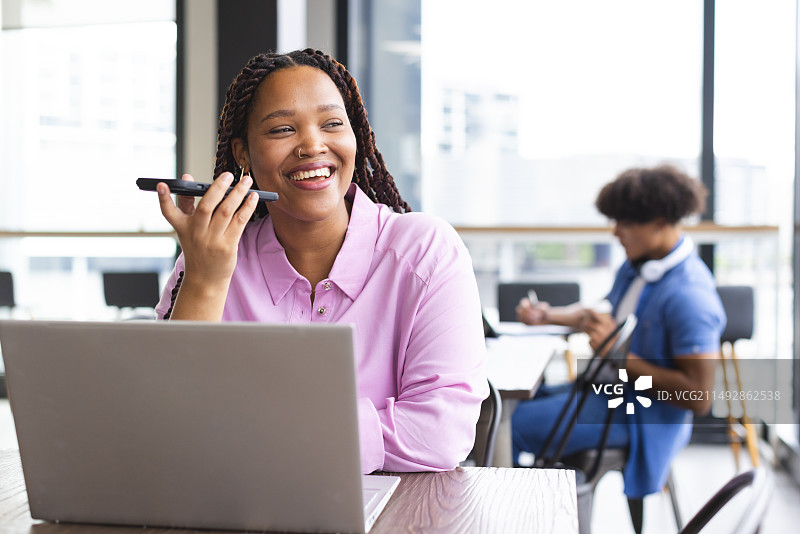 在现代办公室工作的混血辫发女人图片素材