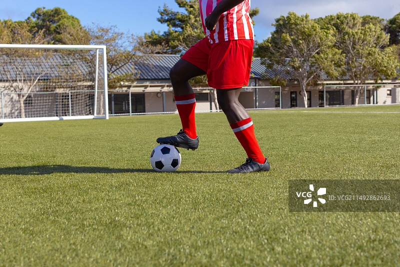 身穿红色制服的年轻非裔美国男运动员控球图片素材