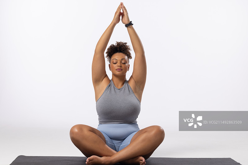 混血加大码模特在白色背景上练习瑜伽，留有文案空间图片素材