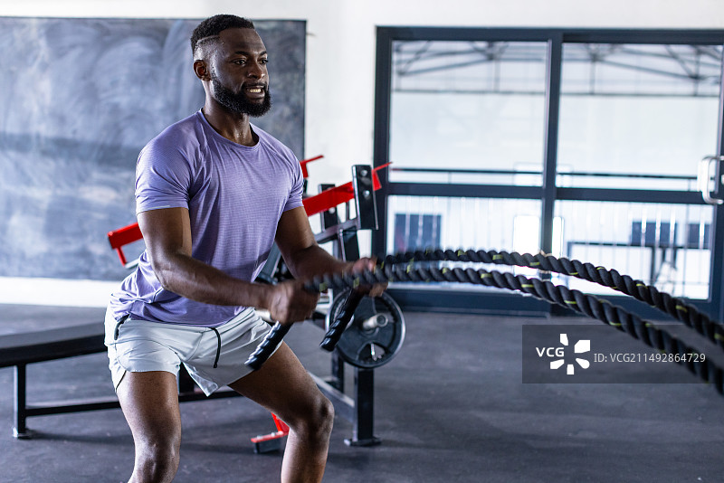 在健身房用粗绳训练的年轻非裔美国男运动员图片素材
