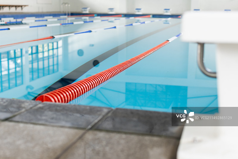 戴着泳帽和泳镜的游泳者在室内游泳池中比赛，有复制空间图片素材