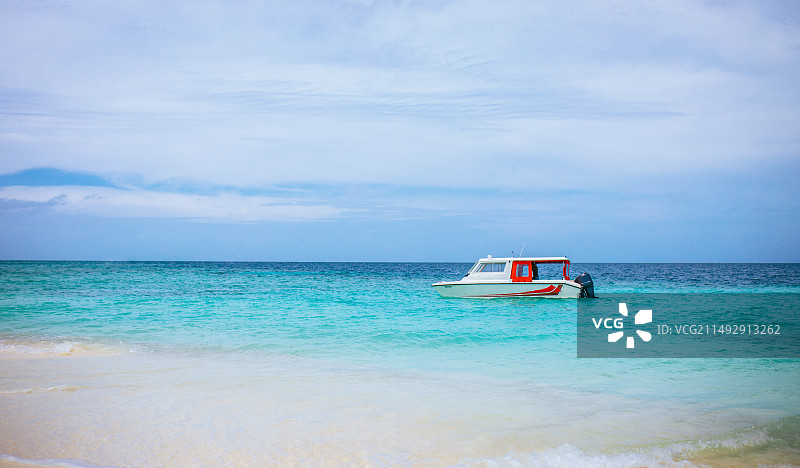 晴天的马尔代夫海面上，有一艘游船在航行图片素材