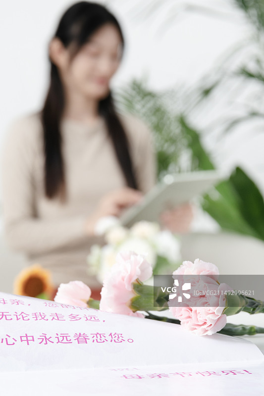 母亲节贺卡与坐在沙发上的的中国女人图片素材