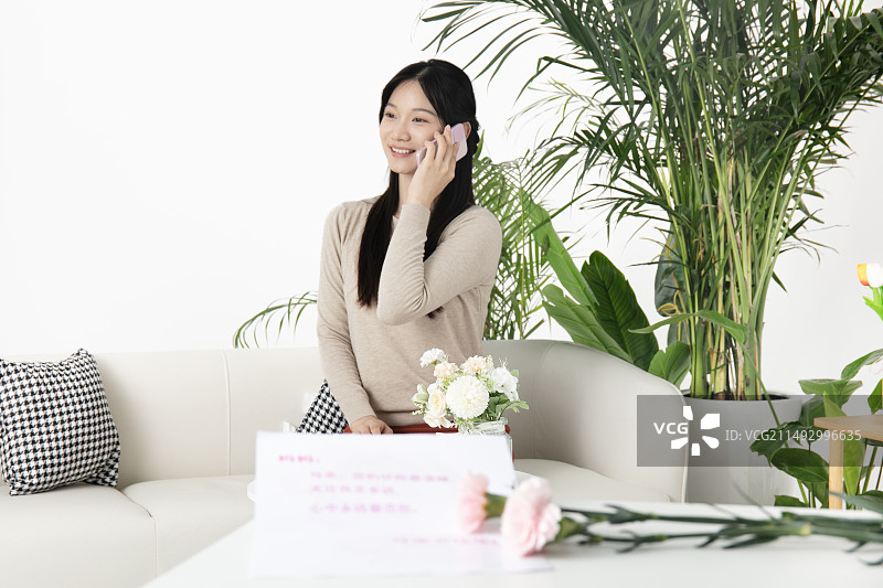 母亲节贺卡与坐在沙发上的的中国女人图片素材