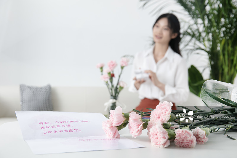 母亲节贺卡与坐在沙发上的的中国女人图片素材