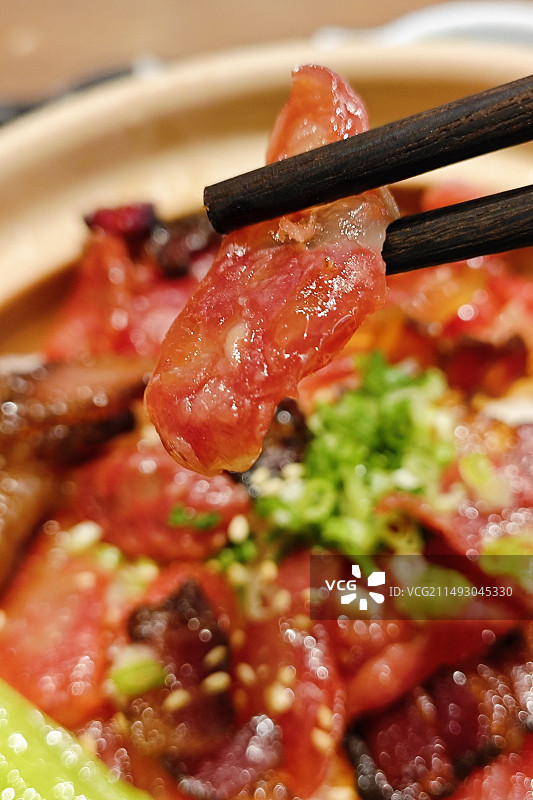 筷子夹着一片腊肠的煲仔饭展示图片素材