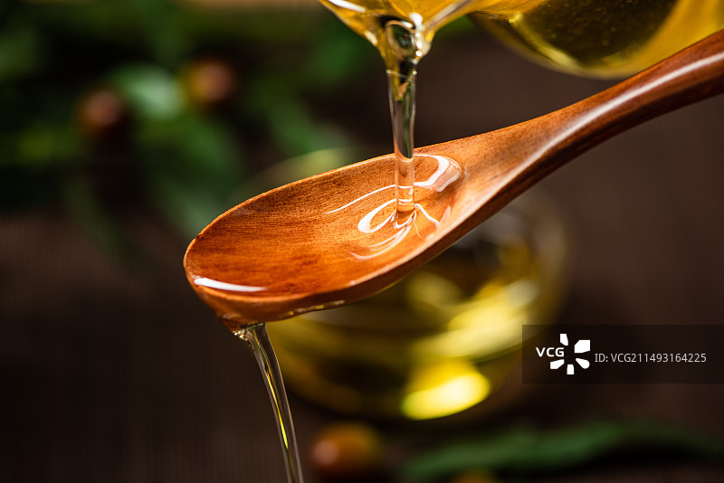 勺子里倒入新鲜橄榄油图片素材