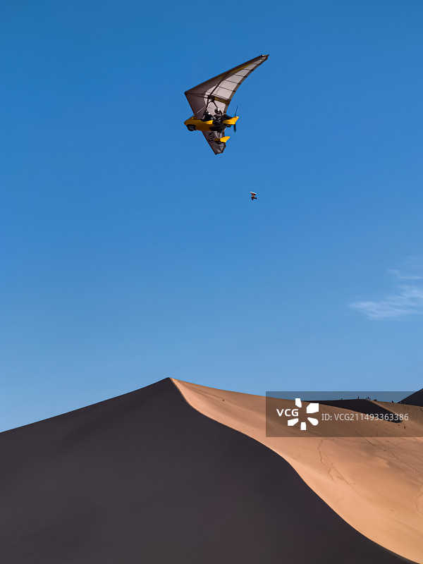 敦煌鸣沙山上空的滑翔机图片素材