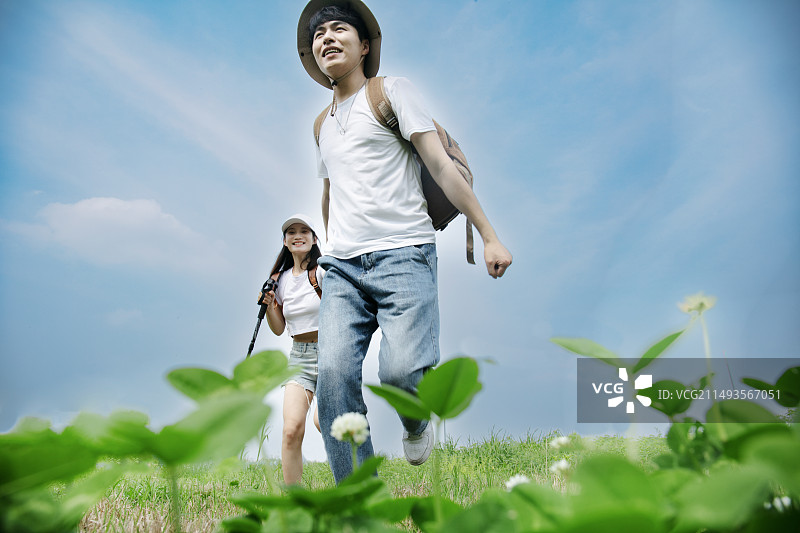 户外徒步奔跑在山顶的年轻情侣图片素材