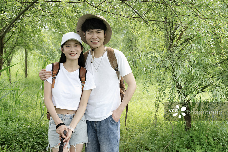 在森林里徒步的搂住肩膀的年轻情侣图片素材