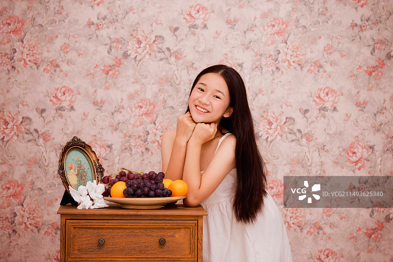 微笑的女孩撑在桌子上图片素材