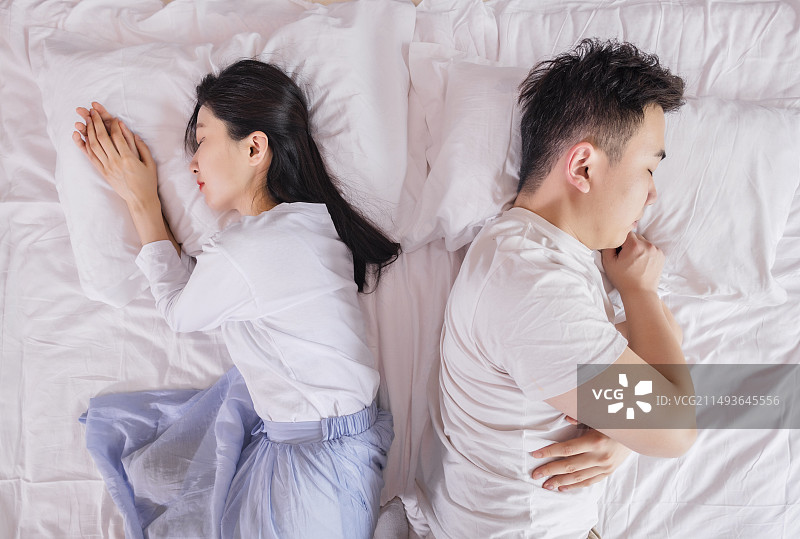 卧室里躺在床上吵架的年轻情侣图片素材