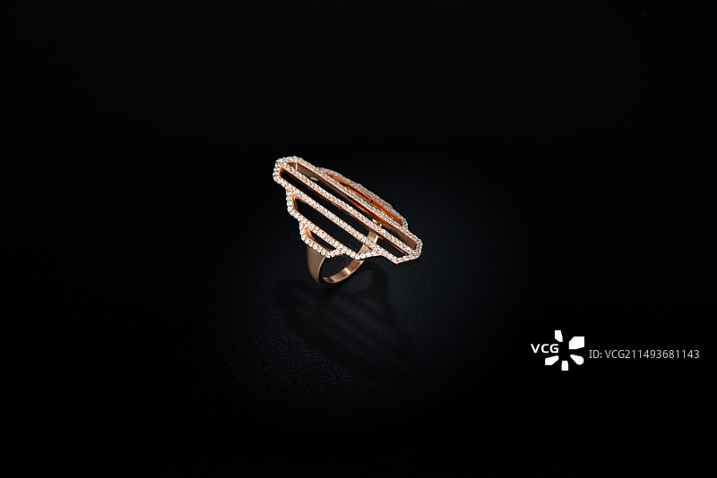黑色背景下时尚钻石金戒指特写镜头图片素材