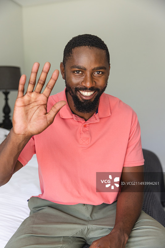 在家中床上进行视频通话的黑人男子图片素材