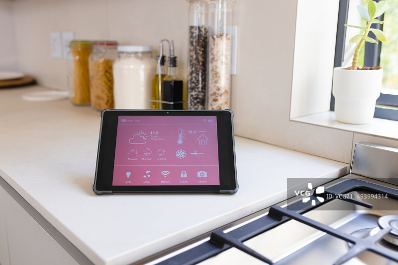 厨房台面上放着显示智能家居界面的平板电脑图片素材