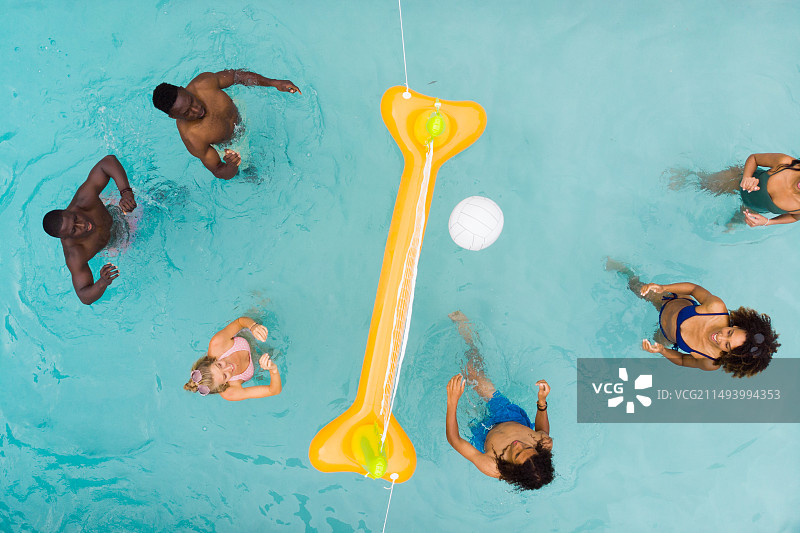 朋友在阳光明媚的游泳池里玩排球游戏的俯视图图片素材