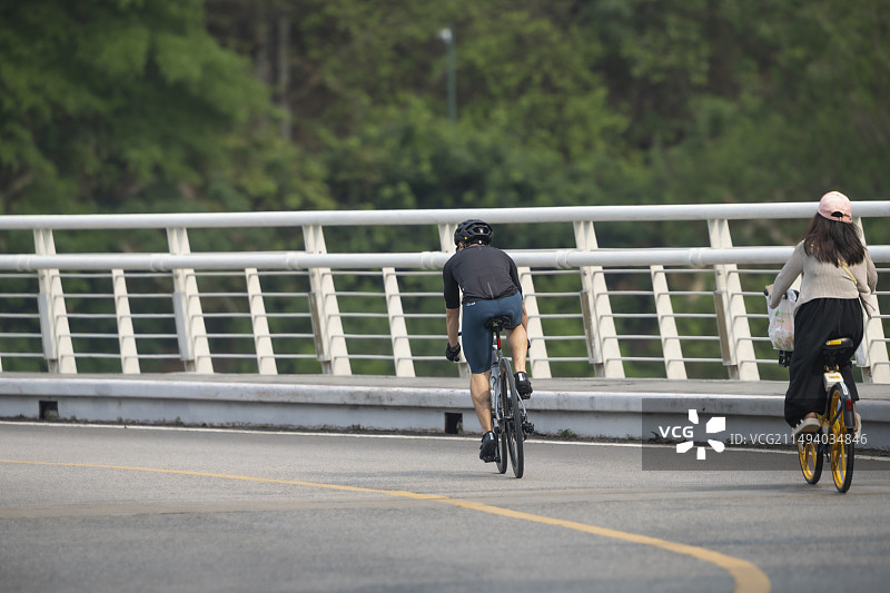 年轻人在柏油路弯道上骑行图片素材