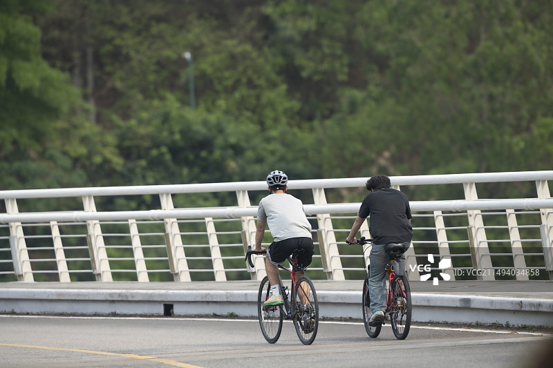 年轻人在柏油路弯道上骑行图片素材