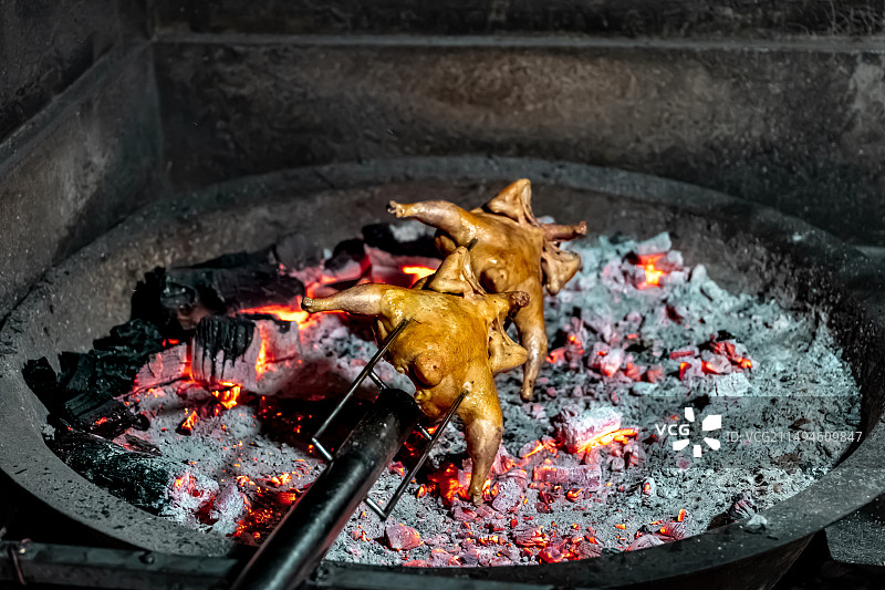 烧烤架上荔枝木烤鸡的高角度视图图片素材