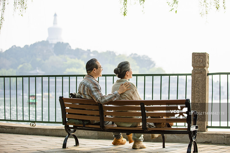 老年人City walk系列:老年夫妻坐在北京北海公园长椅上休息图片素材
