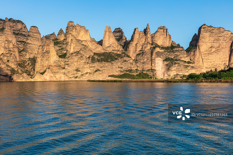 甘肃临夏永靖县炳灵寺石窟丹霞地貌黄河石林，黄河波光粼粼，河岸边石林奇峰耸立，得名“万笏朝天”图片素材