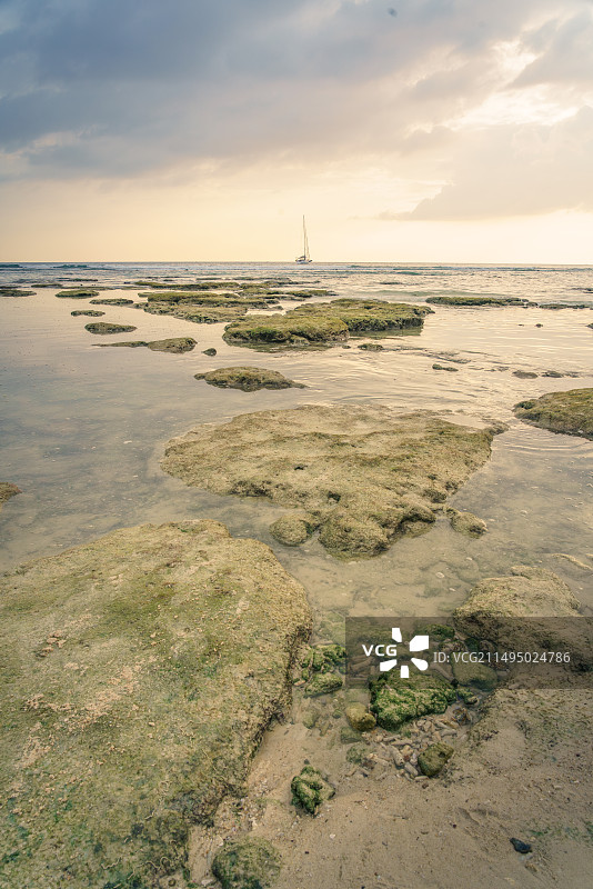夏天日落时分的海滩礁石与海水图片素材