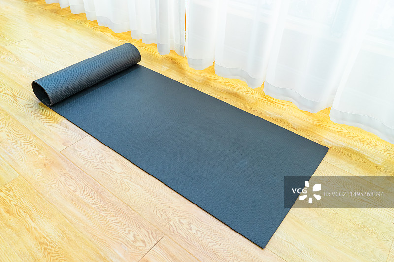 中国室内的瑜伽馆，木地板上，白色的窗帘，木质地板上的放置展开黑色的瑜伽垫，室内无人图像摄影图片素材