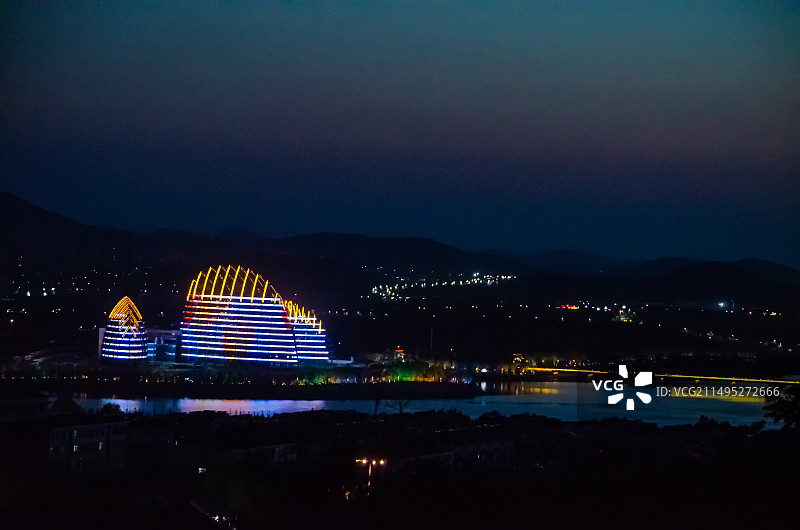 中国山东省泰安市，城市夜晚夜市拍摄主题，泰山天平湖公园标志性建筑和远处的山脉，户外夜晚无人图像摄影图片素材