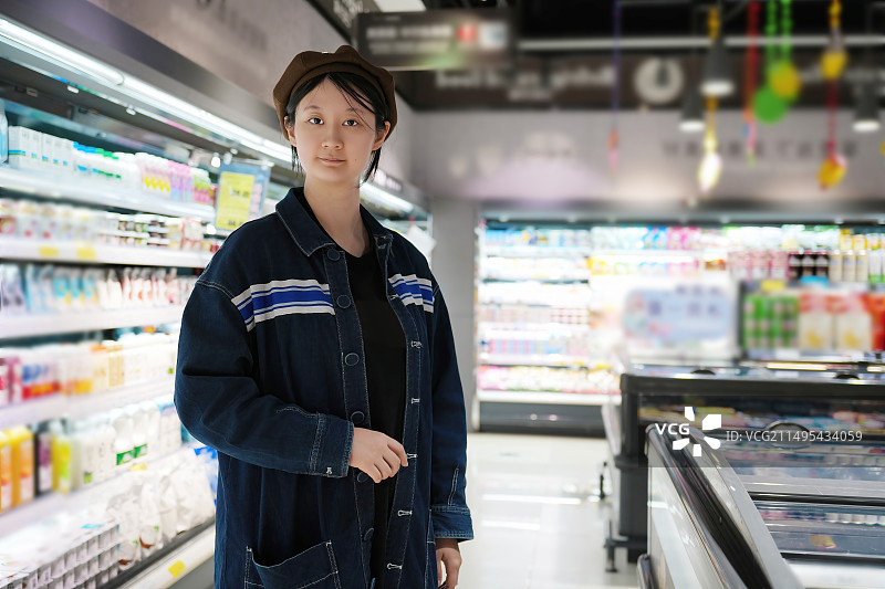 休闲购物者在超市过道中的选择思考图片素材